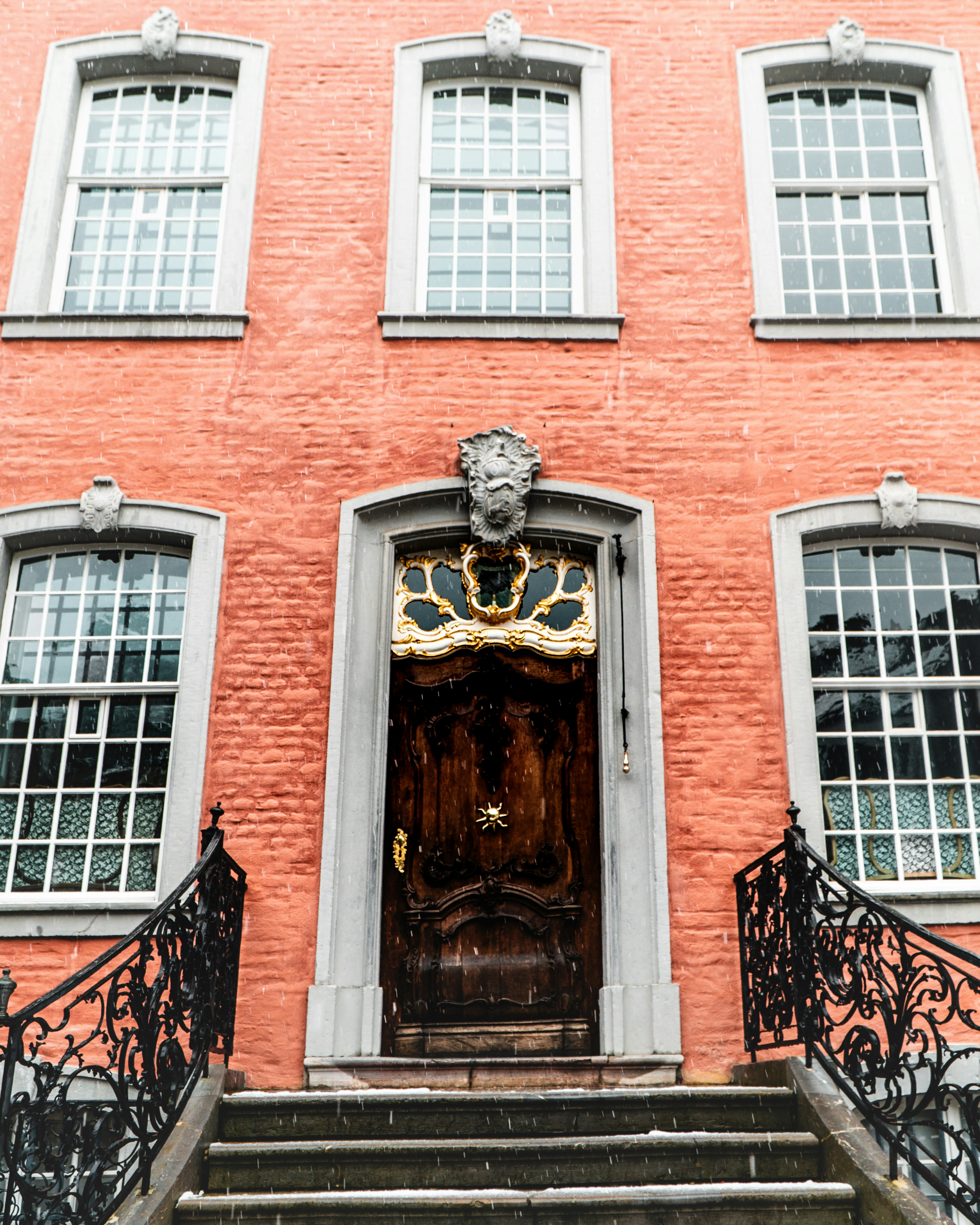 brown wooden door on red brick building